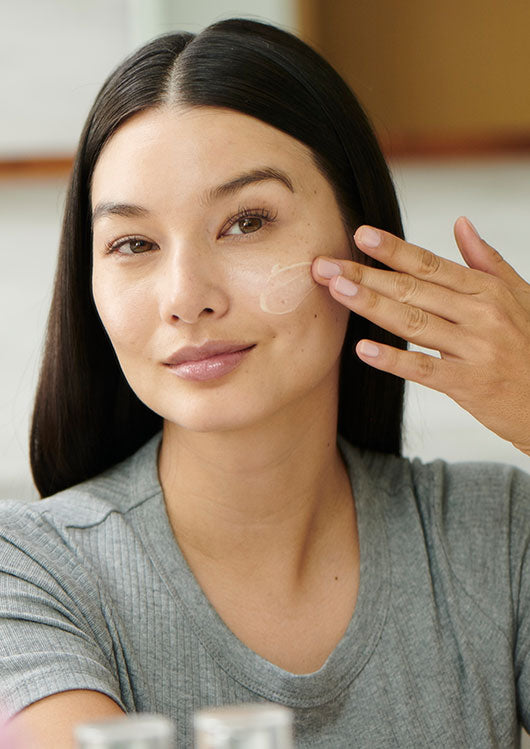 A Girl applying cream on her face.